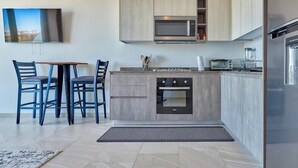 A modern kitchen with a built-in oven, microwave, and a large refrigerator.