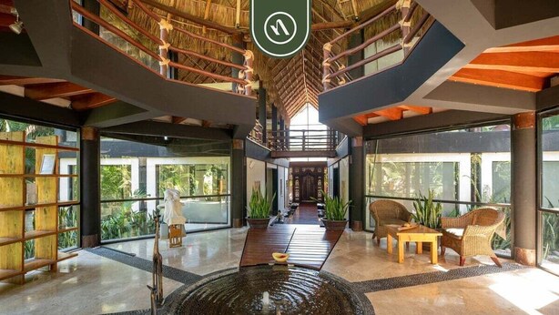 A spacious lobby with a central water feature, wooden furniture, and large windows. - 3BR Condo in the Krystal Grand Hotel - Beach (Nuevo Nayarit)