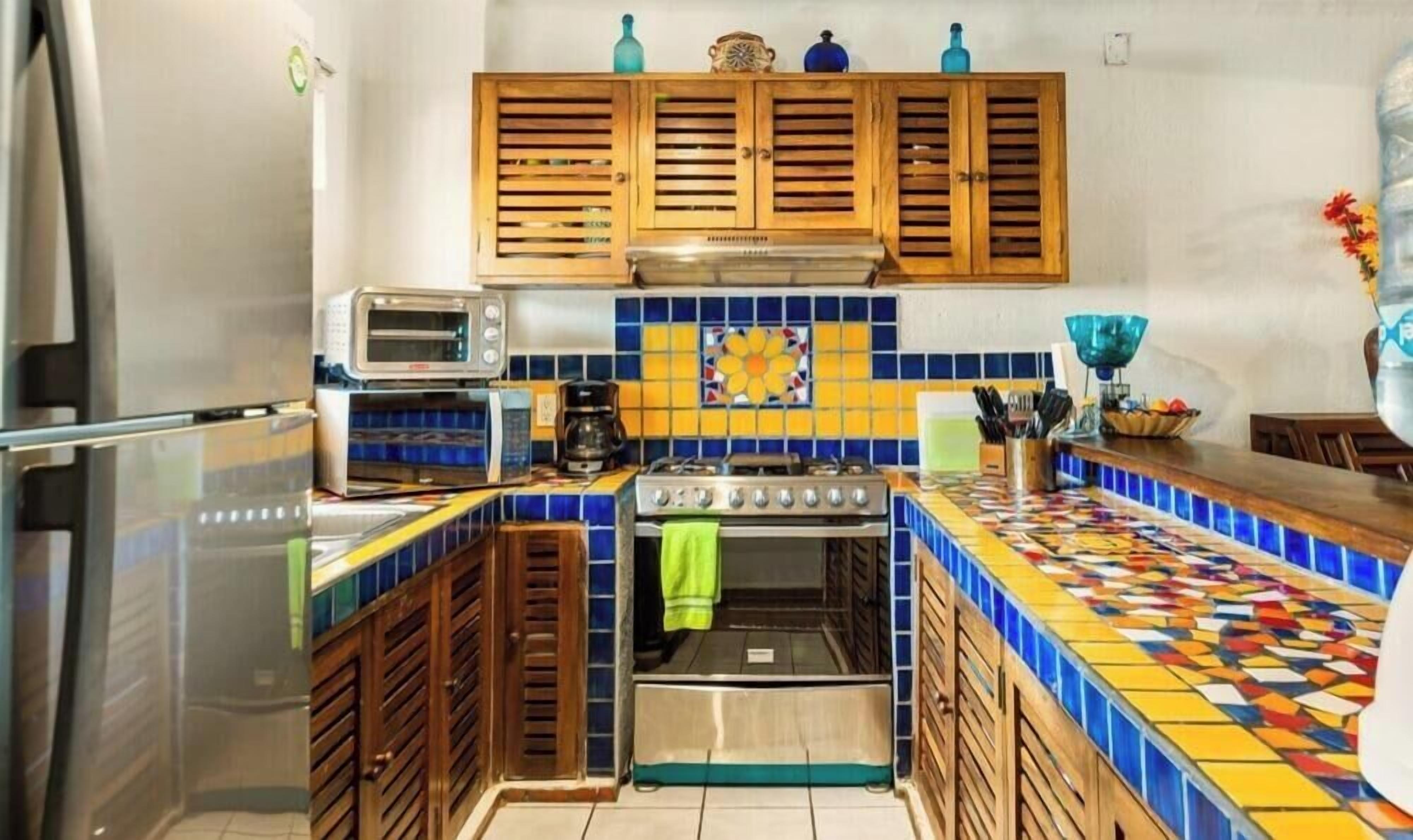Une cuisine avec des meubles en bois, un pare-feu en carreaux, une cuisinière et un four à micro-ondes.