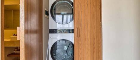 Un lavadero con dos lavadoras apiladas.