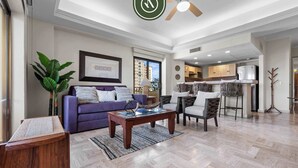 A spacious living room with a sofa, coffee table, and chairs. There is a kitchen area visible in the background. - Beachfront 2 BR Condo - Beach - Pools - Tennis (Puerto Vallarta)