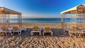 A beach with sun loungers and umbrellas under a clear sky. - Beachfront 2 BR Condo - Beach - Pools - Tennis (Puerto Vallarta)