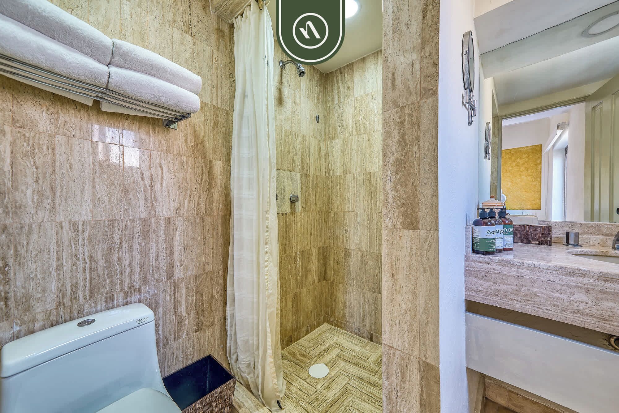 Een badkamer met een douche, toilet en een wastafel met spiegel.