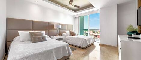 Ein modernes Hotelzimmer mit zwei Betten, einem Deckenventilator, einem großen Fenster mit Blick und einem Flachbildfernseher.