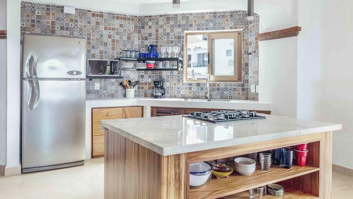 Une cuisine moderne équipée d’un réfrigérateur en acier inoxydable, d’un four à micro-ondes et d’une cuisinière à gaz.