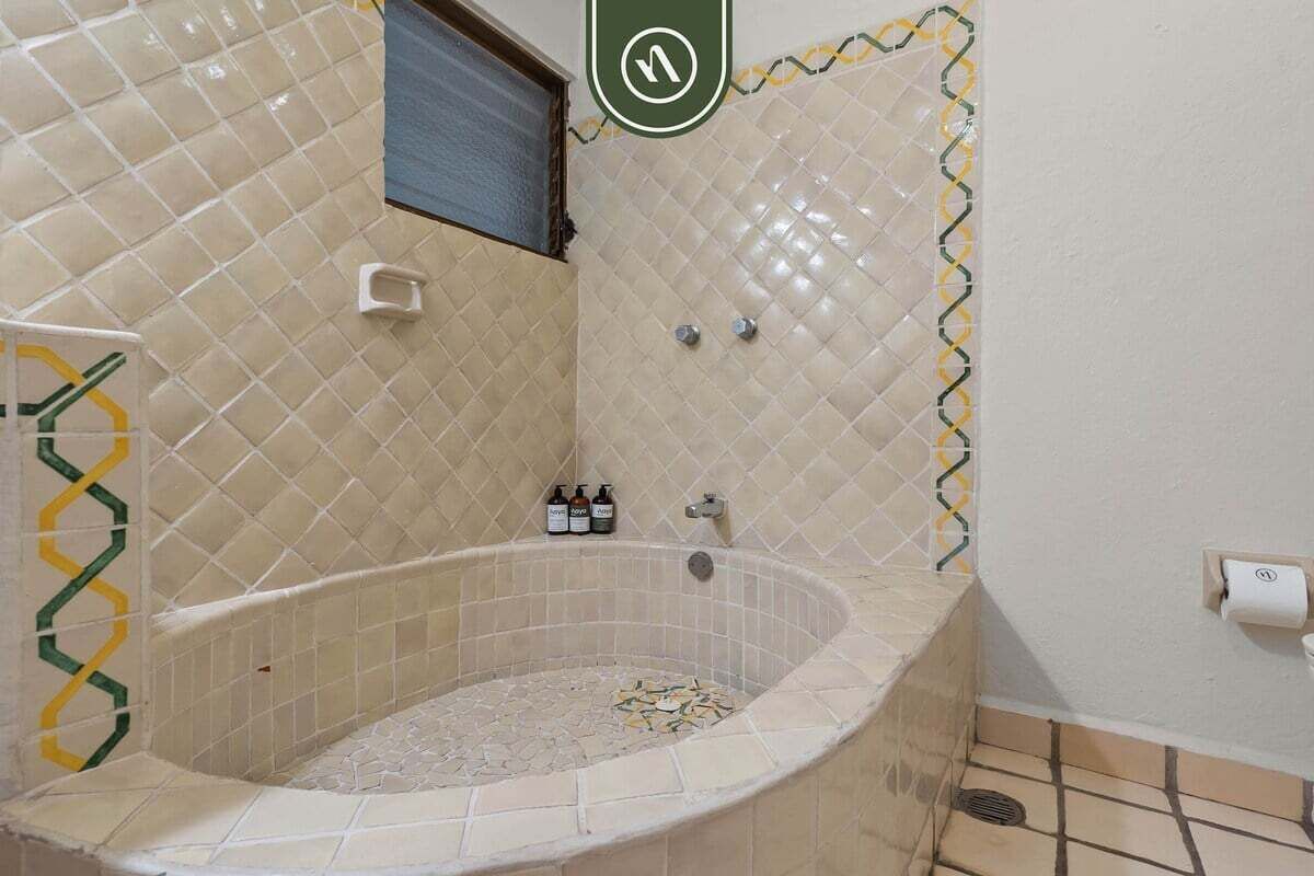 A bathroom with a freestanding bathtub, a towel rack, and a small window.