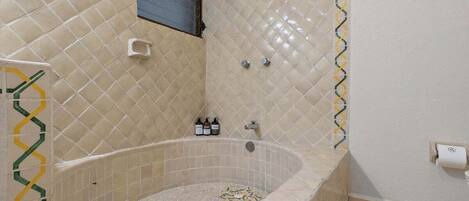 A bathroom with a freestanding bathtub, a towel rack, and a small window.