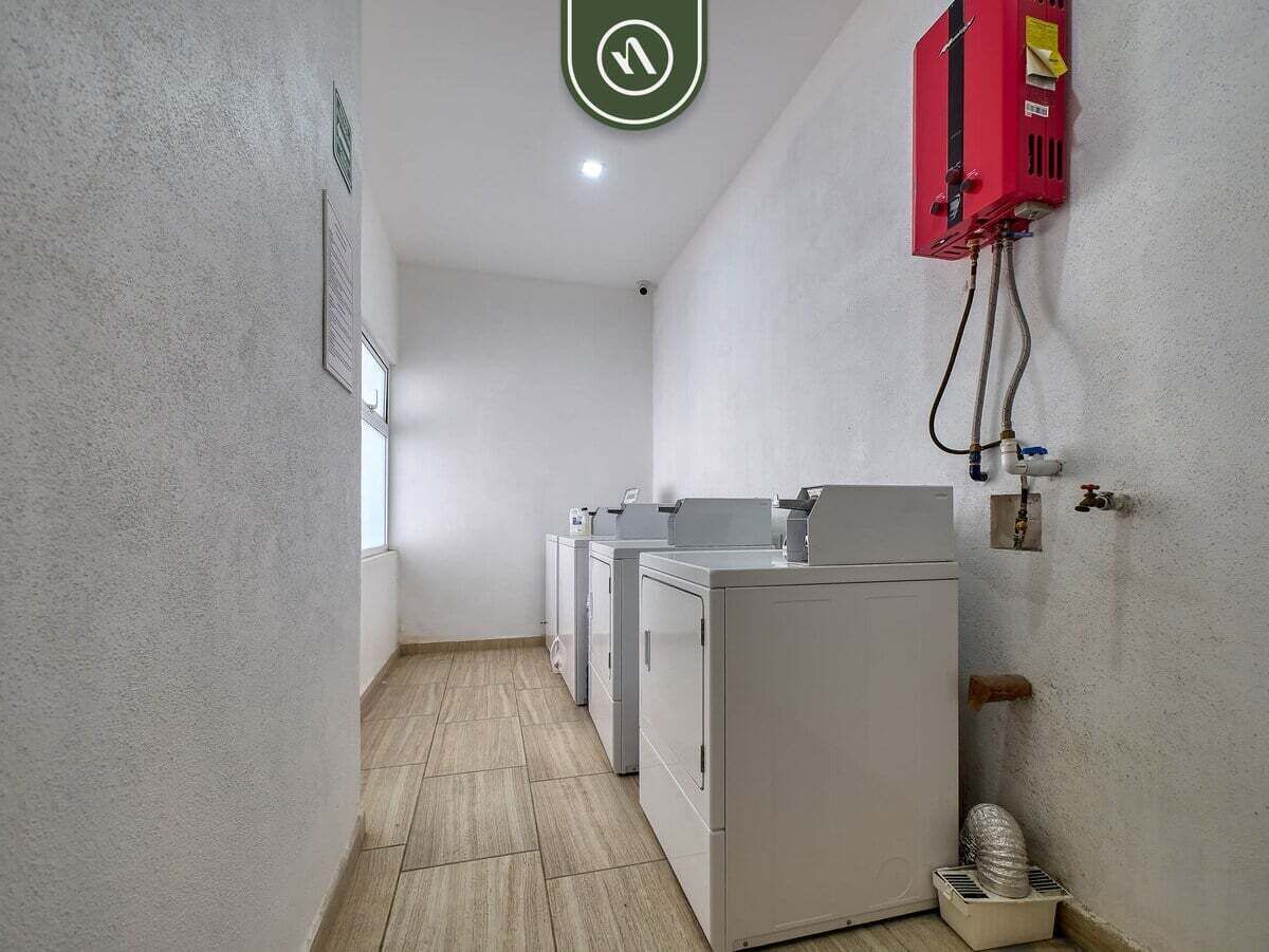 A laundry room with a washing machine, dryer, and a red utility box.