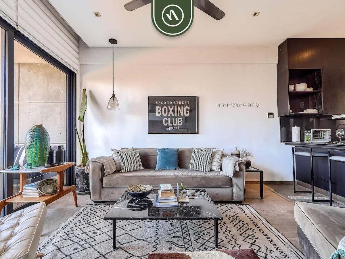A modern living room with a sofa, coffee table, and a framed sign on the wall.