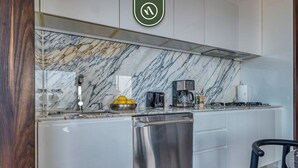 Eine moderne Küche mit Marmorfliesenspiegel, Edelstahlgeräten und einem minimalistischen Design.