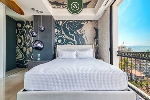 Une chambre à coucher moderne avec un grand lit, une vue sur la ville et un décor mural original.