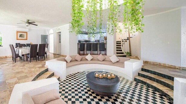 A modern living room with a checkered floor, a round coffee table, and a sofa with cushions. - Amazing House -private Pool - Tennis - Paddle Cour (Acapulco)