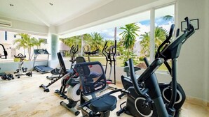 A gym with various exercise equipment including treadmills, stationary bikes, and weight machines. - Amazing House -private Pool - Tennis - Paddle Cour (Acapulco)