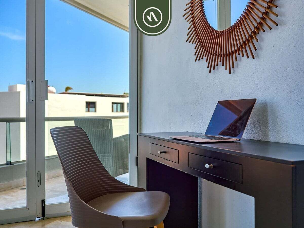 Un espacio de oficina moderno con un escritorio, una silla y una computadora portátil.