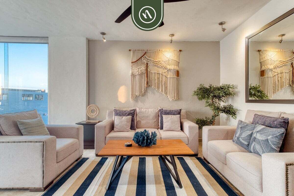 A modern living room with a sofa set, a coffee table, and a large mirror.