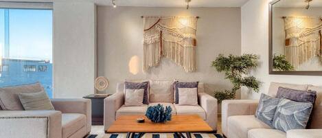 A modern living room with a sofa set, a coffee table, and a large mirror.