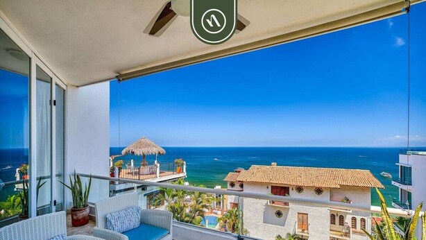 Un balcone con mobili in vimini e vista sull'oceano.