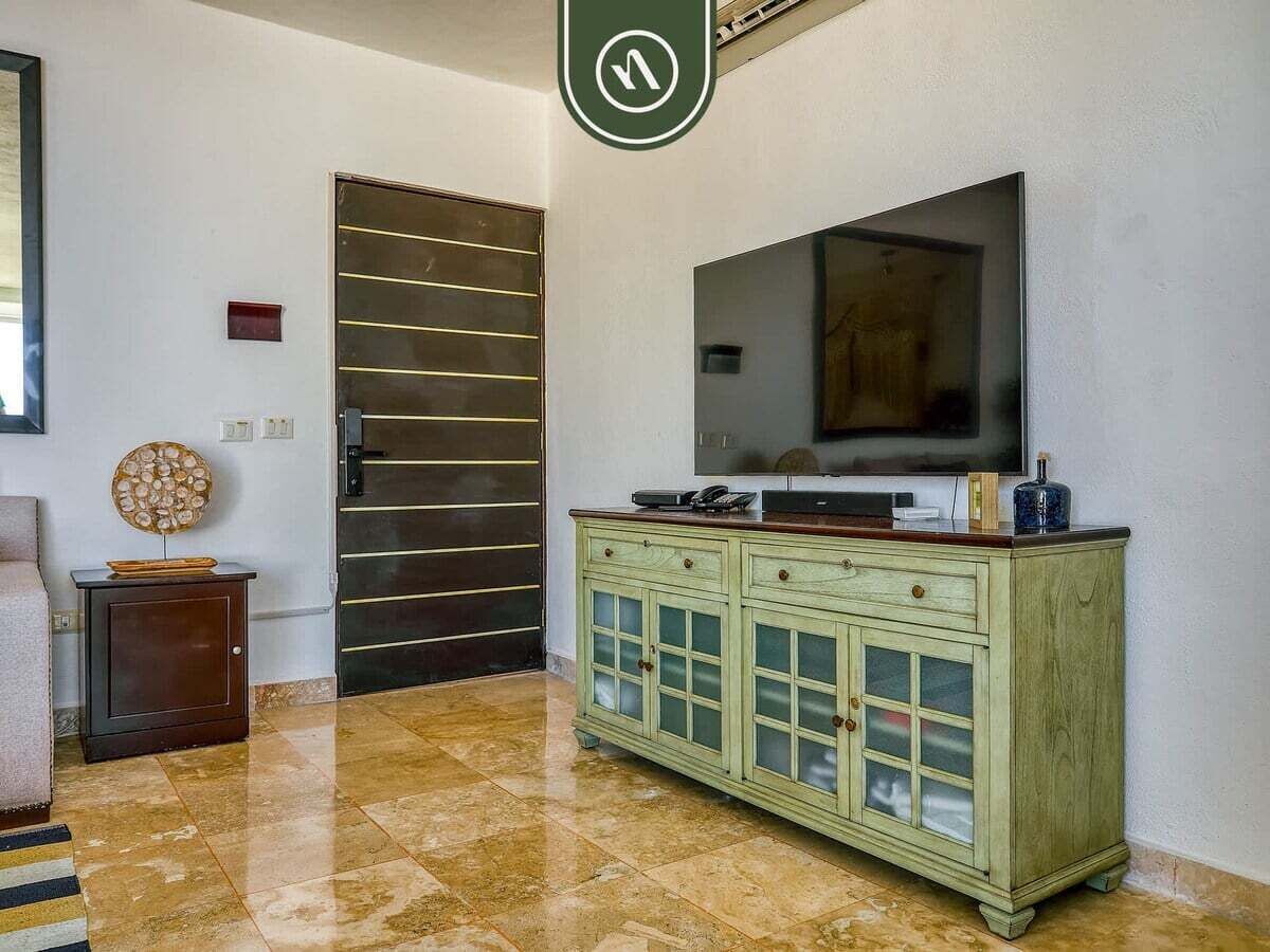 Una habitación con un armario grande, un televisor y una puerta con líneas horizontales.