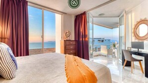 Una camera d'albergo con un letto, una scrivania, una sedia, una TV e vista mare.