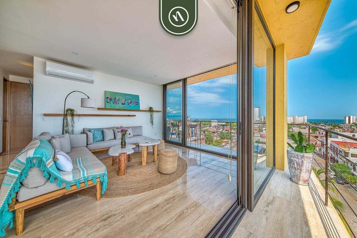 A modern living room with a sofa, coffee table, and a view of the city.