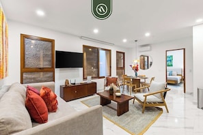 Una sala de estar moderna con sofá, una mesa de centro y un comedor con sillas.