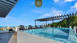 A rooftop infinity pool with a pergola, lounge chairs, and a view of the ocean. - New 1 BR Condo - Rooftop Pool - Romantic Zone (Puerto Vallarta)