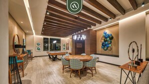 A modern conference room with a wooden table, chairs, and a pool table.