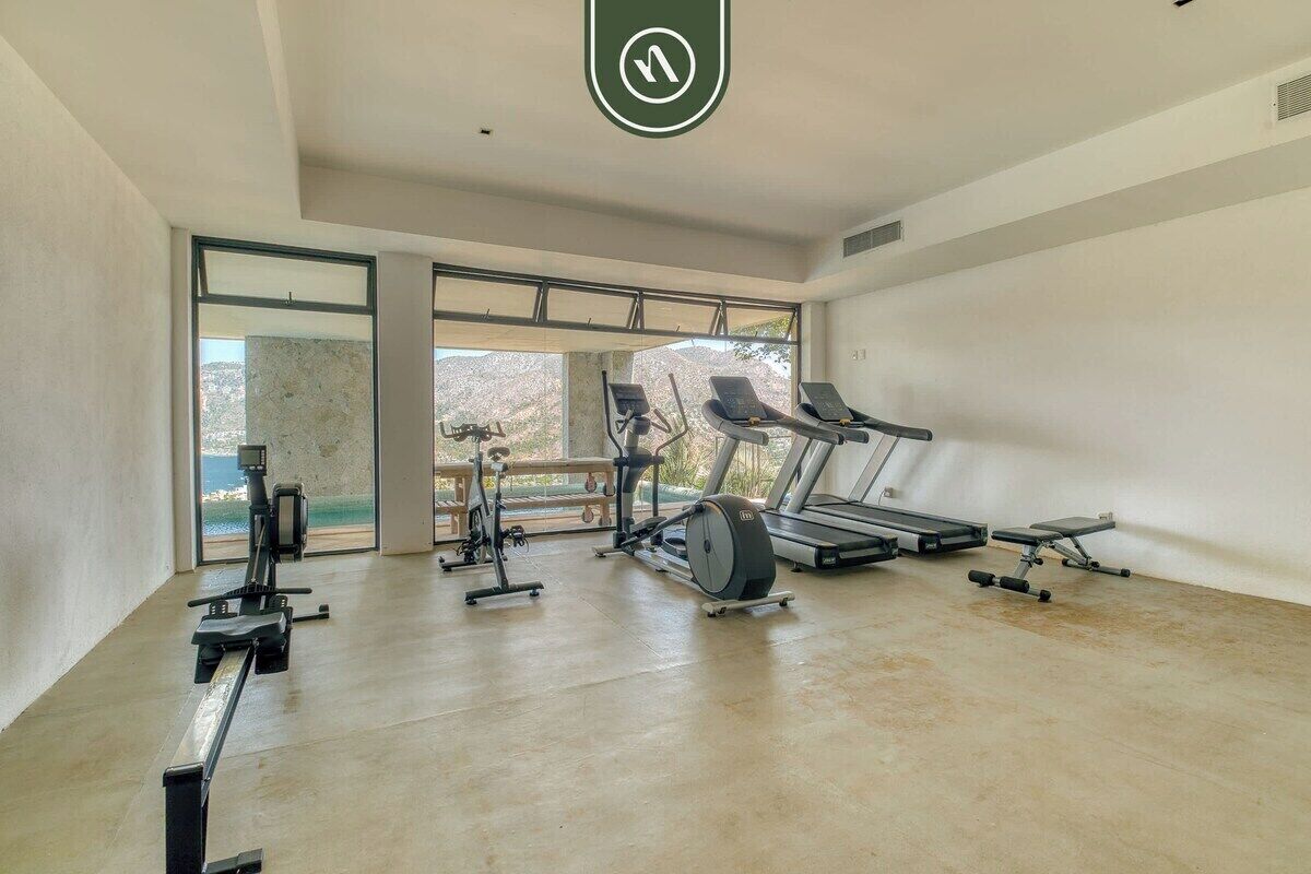 Ein modernes Fitnessstudio mit Cardiogeräten, Laufband und Rudergerät.
