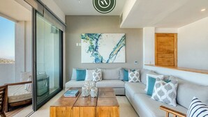 A modern living room with a sofa, coffee table, and artwork. - Luxury 4 BR Condo - Amazing Bay View - Pool (Acapulco)
