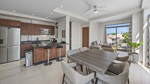 Eine moderne Küche mit Essbereich, Deckenventilator und Blick ins Freie.