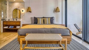 A modern bedroom with a large bed, bedside tables, a mirror, and a window. - Luxury Studio in Romantic Zone - Infinity Pool (Puerto Vallarta)