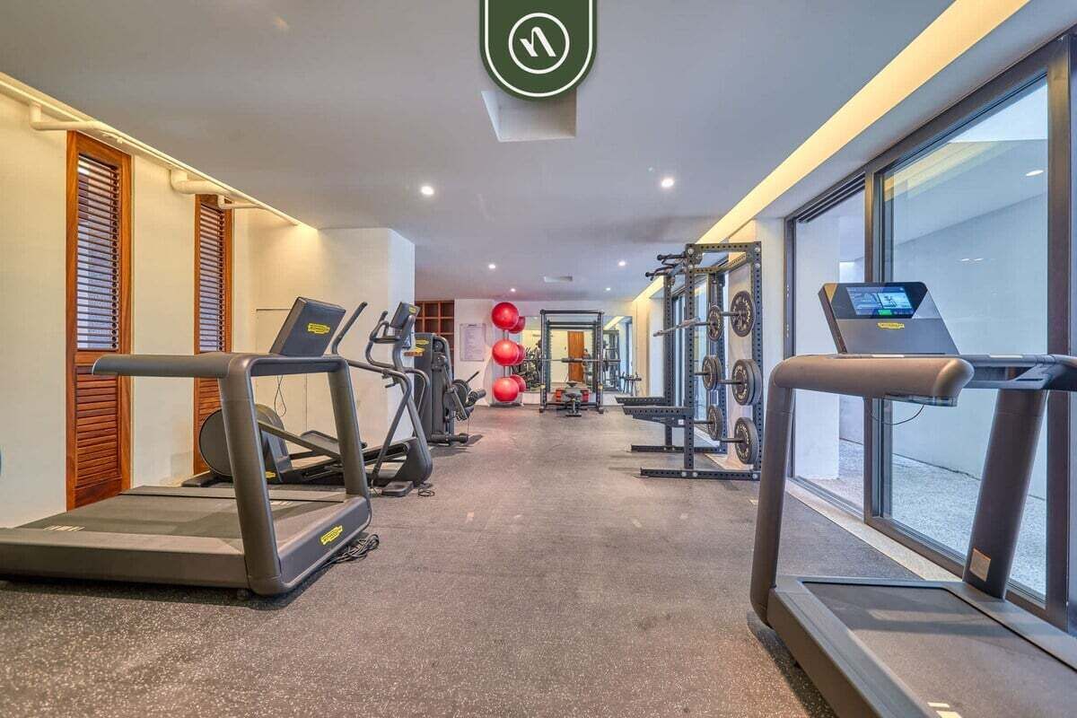 A gym with treadmills, weight machines, and exercise balls.