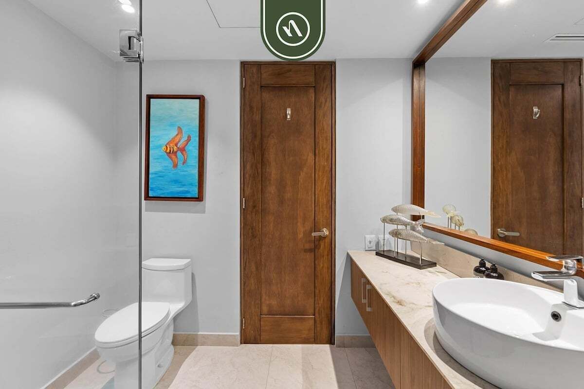 A modern bathroom with a toilet, a sink, and a wooden door.