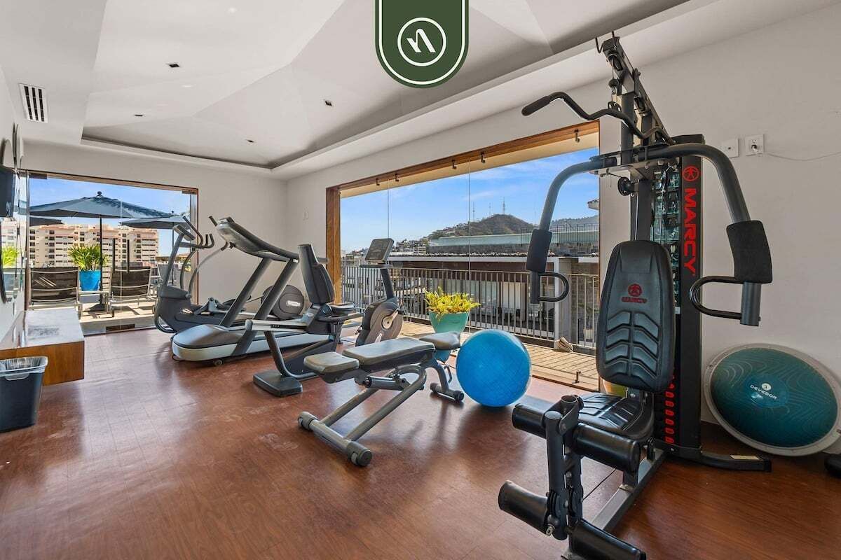 Una palestra con tapis roulant, macchinari per pesi e palloni da ginnastica.
