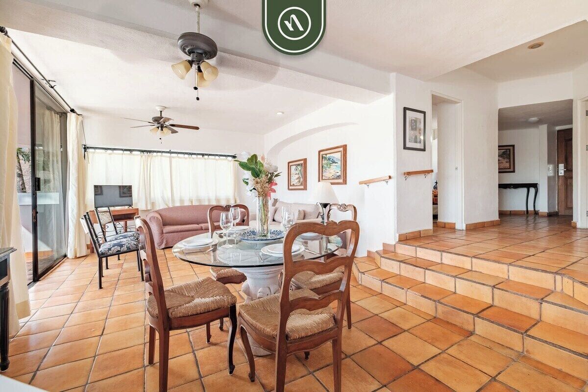 A dining area with a round table, chairs, and a ceiling fan.