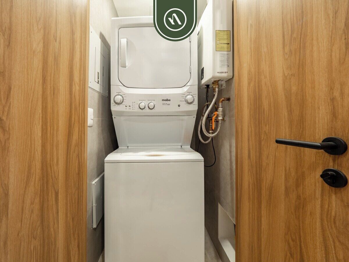 A compact, modern bathroom with a white toilet, a small sink, and a shower unit.