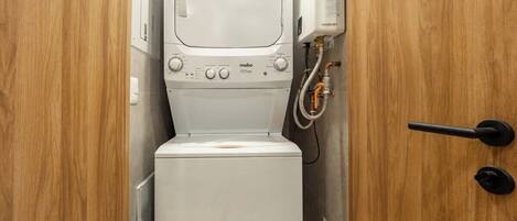 A compact, modern bathroom with a white toilet, a small sink, and a shower unit.