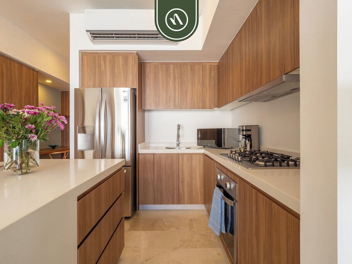 A modern kitchen with wooden cabinets, stainless steel appliances, and a central island.