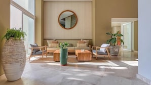 Amplia sala de estar con sofá, mesa de centro y plantas en macetas.