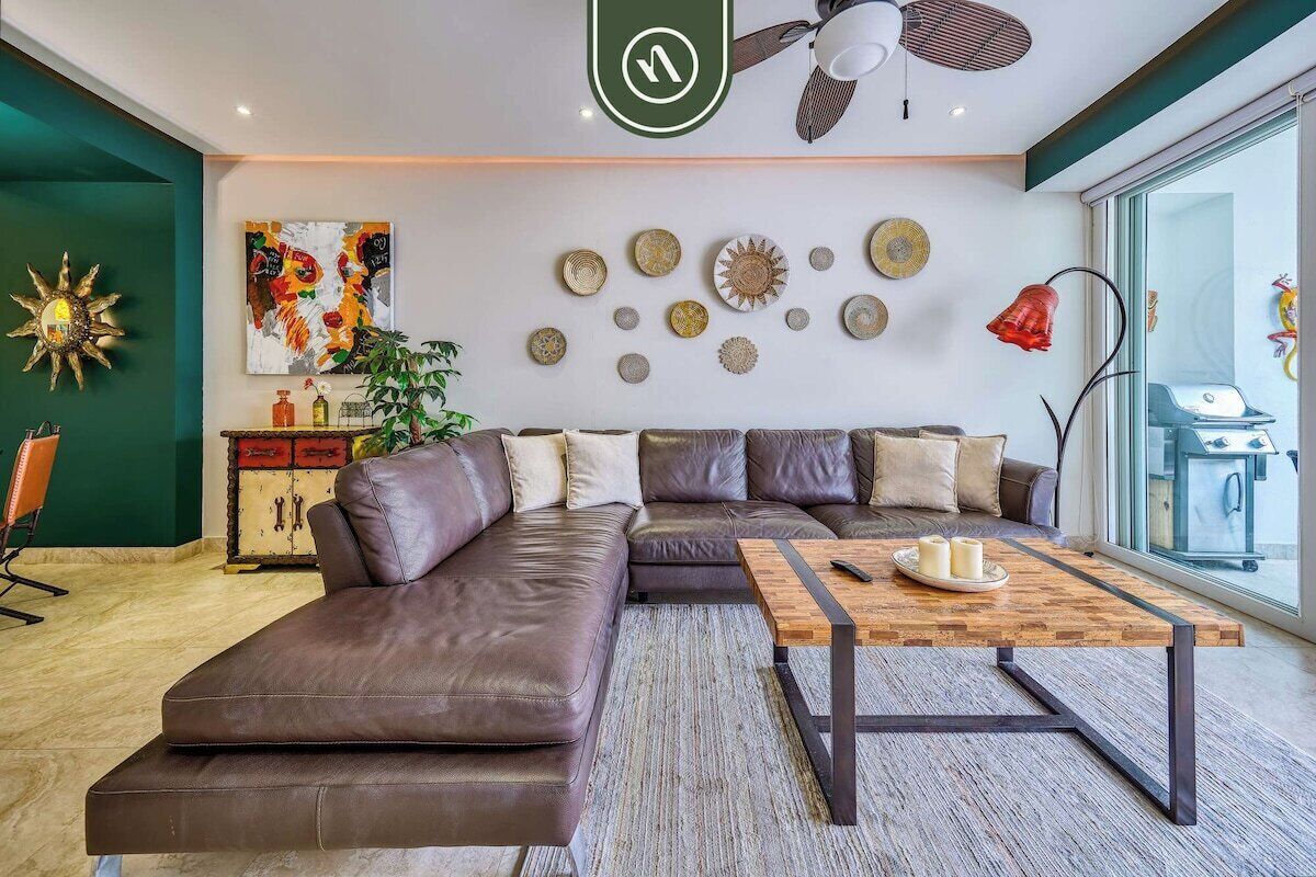 Een moderne woonkamer met een modulaire bank, een houten salontafel en decoratieve muurkunst.