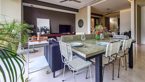 A modern dining area with a large table, chairs, and a ceiling fan. - Luxury 1 BR Condo in Pier 57 - Infinity Pool (Puerto Vallarta)
