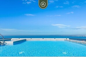 Una piscina con vista al océano y un cielo despejado.