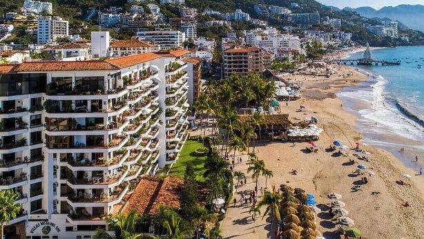 Un hôtel situé sur la côte, doté de nombreux balcons, bénéficiant d’un emplacement en bord de plage et offrant une vue sur l’océan.