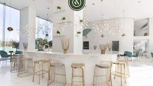 Ein modernes Interieur mit Bar, Barhocker und hängenden Leuchten.
