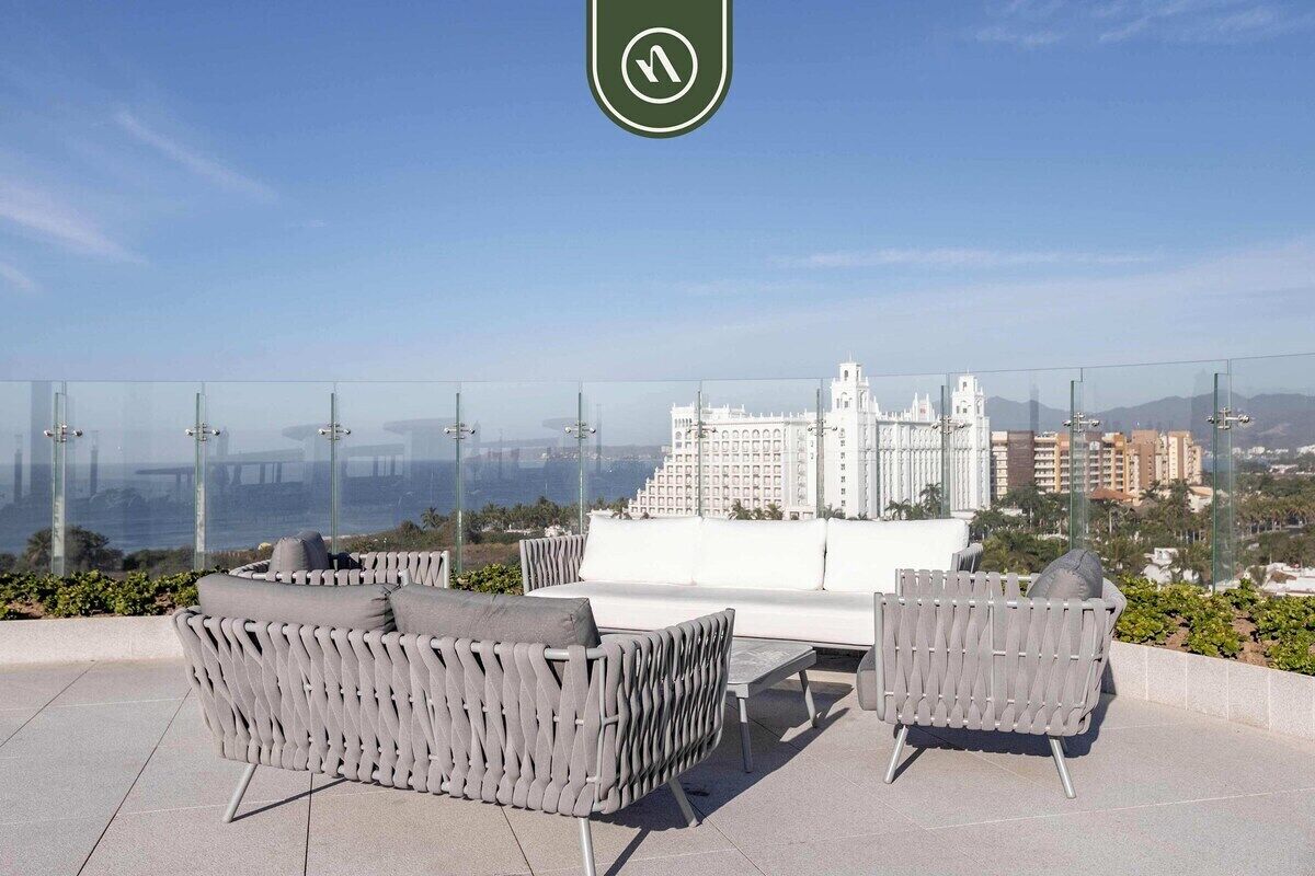 A rooftop terrace with outdoor seating and a view of a cityscape.