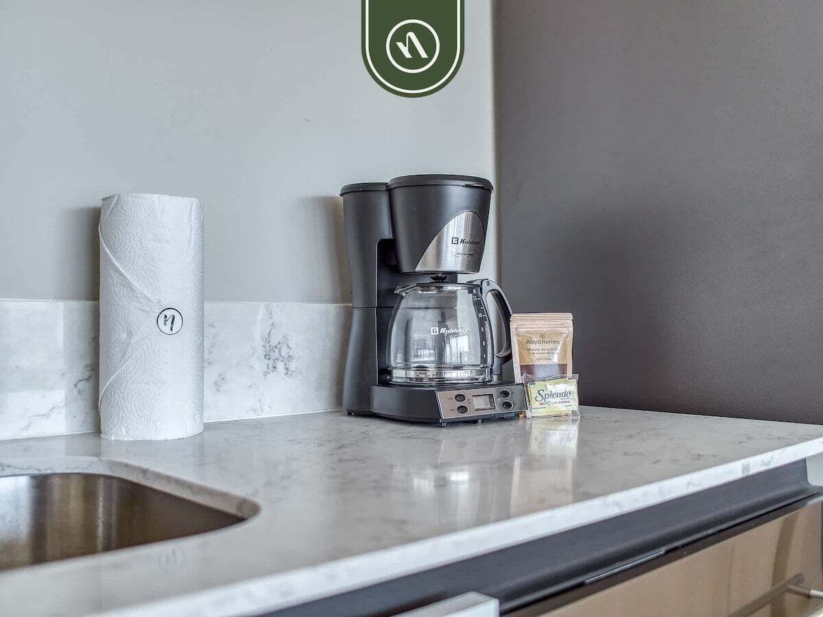 A kitchen with a coffee maker, a paper towel roll, and a box of Splenda.