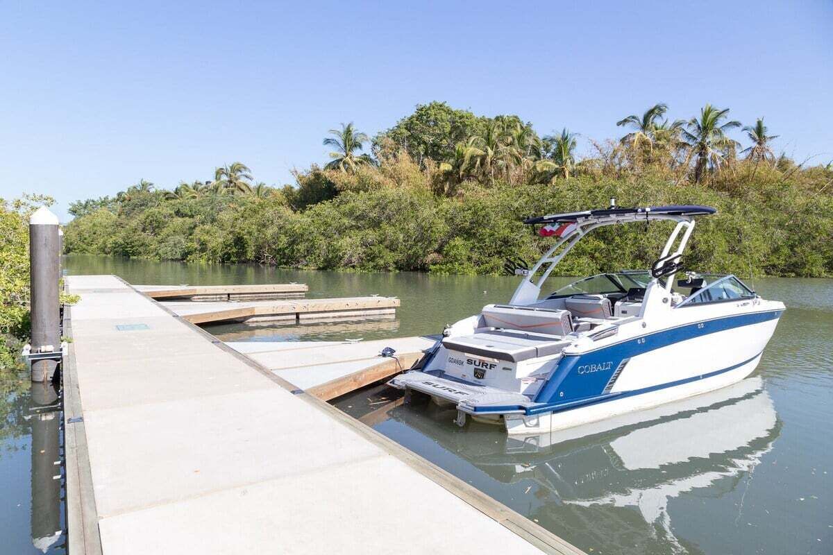 Un bote amarrado en un muelle, con vista despejada al agua y la vegetación circundante.