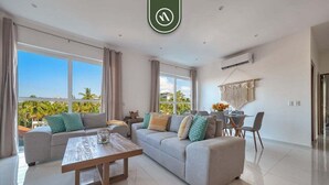 A modern living room with a sofa, coffee table, and dining area. - Equipped 2BR Condo in Versalles - Pool - King Bed (Puerto Vallarta)