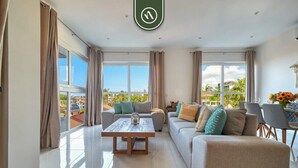 A spacious living room with a sofa, a coffee table, and a dining area with chairs. - Equipped 2BR Condo in Versalles - Pool - King Bed (Puerto Vallarta)