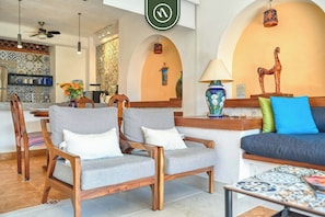 A modern lobby with a reception desk, two grey armchairs, a sofa, and a decorative horse statue. - Ocean View 1Br Condo-balcony-beach-pool - 606 (Puerto Vallarta)